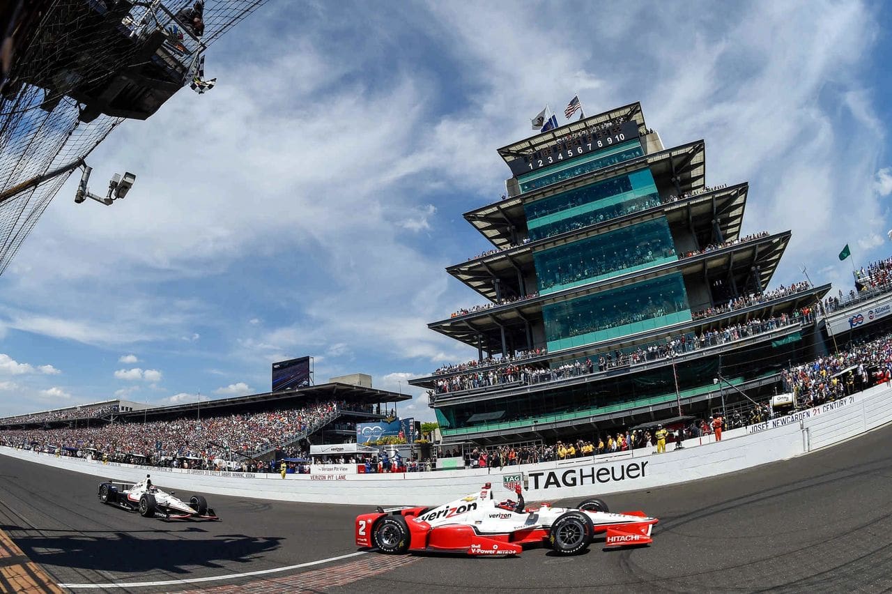 Juan Pablo Montoya takes the checked flag ahead of Penske Racing teammate Will Power for his second Indianapolis 500 victory. 